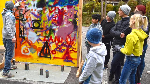 Clemens Bartenbach mit den Jugendlichen beim Gestalten der Graffiti.